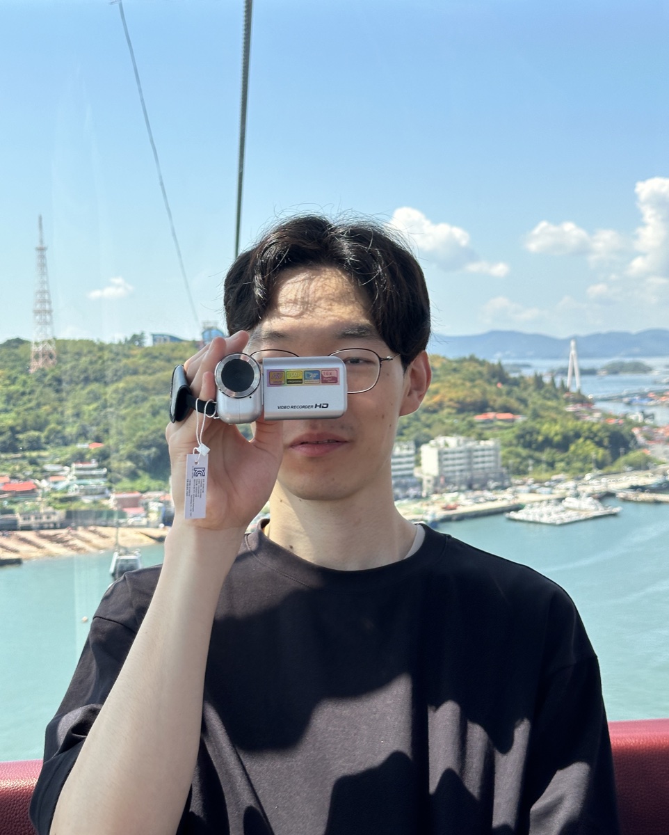 Jongmin Gim holding a camcorder beside the sea